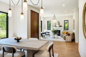 A spacious living area bathed in golden light, accented with blooms and sleek decor.